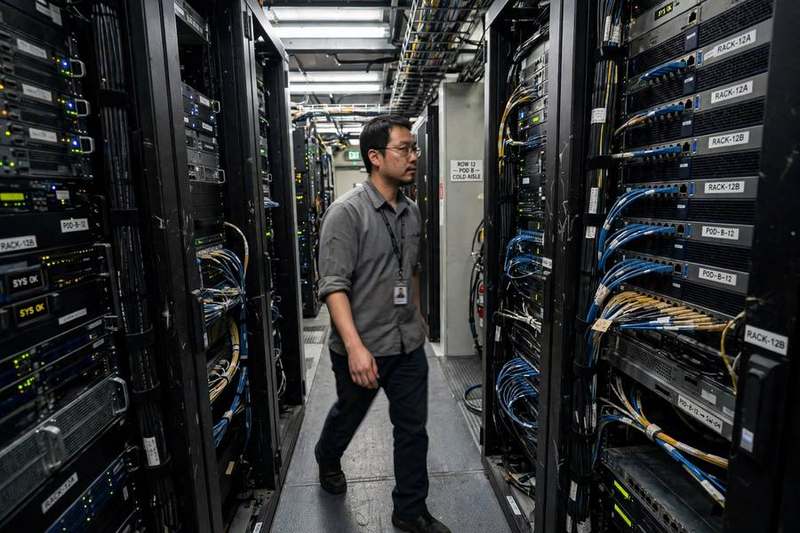 A technician walking between server racks in a data center